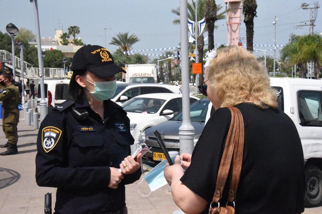 A police officer enforces the order to wear a mask in public (Photo: Israel Police) השוטרים ברחבי הארץ מחלקים לאזרחים מסכות ועוסקים בהסברה על התפשטות נגיף הקורונה