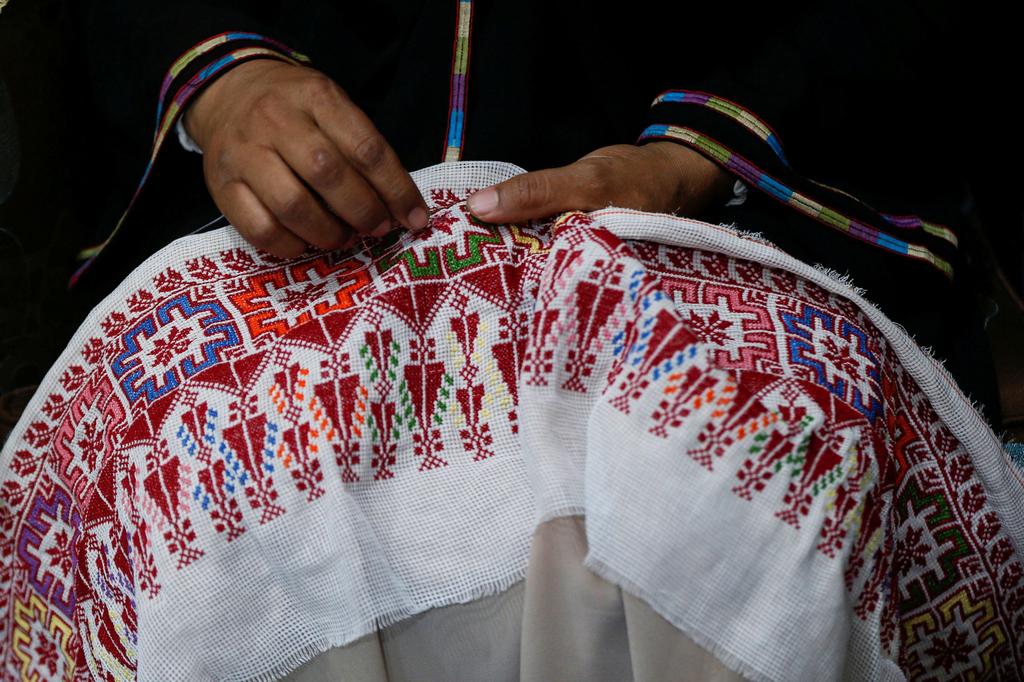 Um Zeid, 47 year-old Palestinian refugee woman living in Jordan embroiders a traditional Palestinian dress for customers at Al-Baqaa Palestinian refugee camp, near Amman, Jordan 