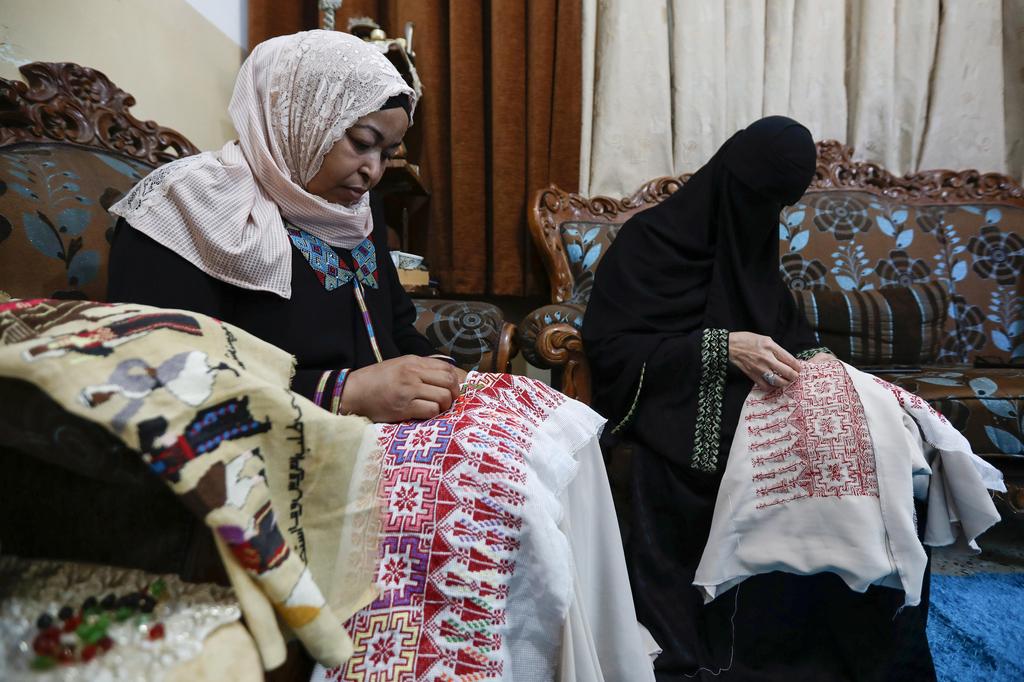 Um Zeid, 47 year-old, and Khawla 48 year-old, Palestinian refugees women living in Jordan embroider a traditional Palestinian dresses for customers at Al-Baqaa Palestinian refugee camp, near Amman, Jordan 