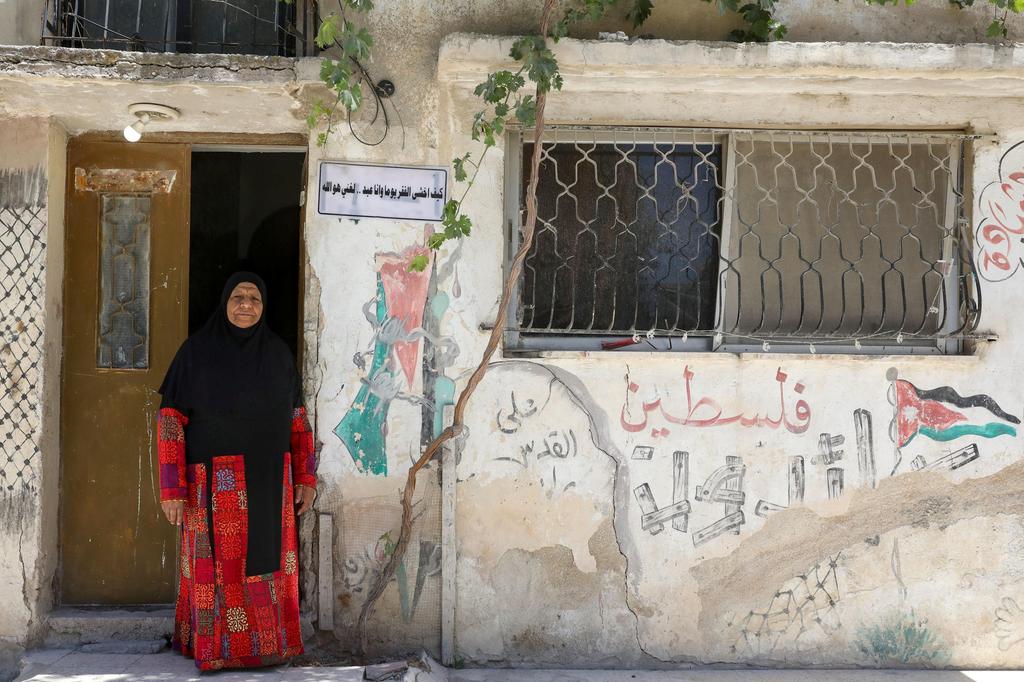 Um Nayef, 74 year-old Palestinian refugee woman living in Jordan, wears the traditional Palestinian dress as she poses in front of her home at Al-Baqaa Palestinian refugee camp, near Amman, Jordan 