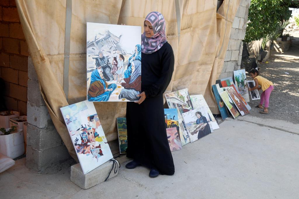 Khadeeja Bisharat, a Palestinian artist, displays a conflict-inspired artwork she has painted, in Jordan Valley, West Bank