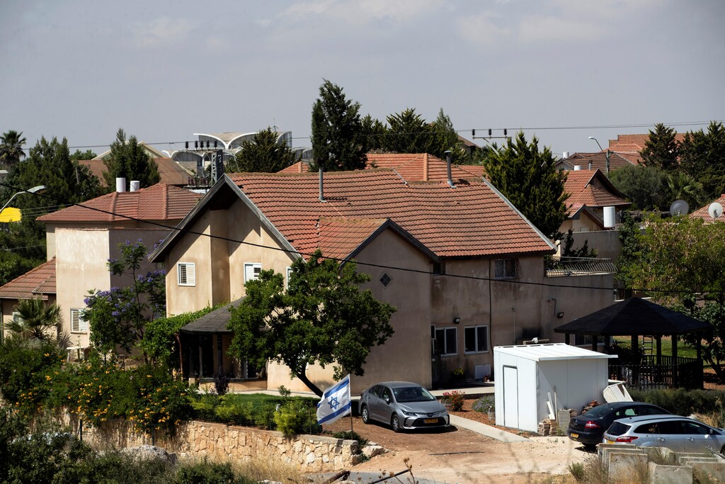 An Israeli flag flutters near houses in the West Bank settlement of Otniel 