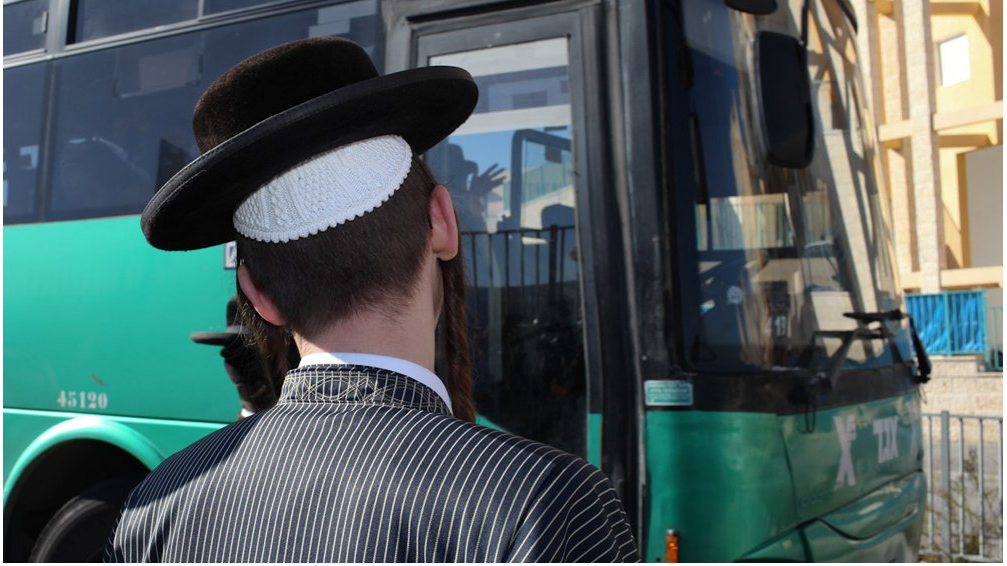  A Haredi man lines up to board a public bus 