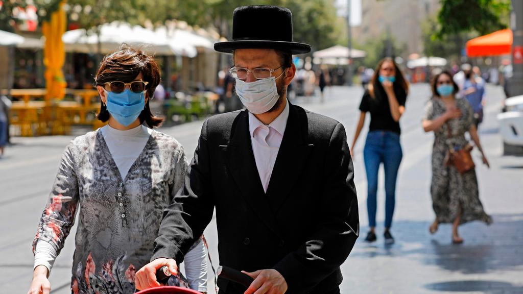  A Haredi couple wears masks as they walk in Jerusalem 