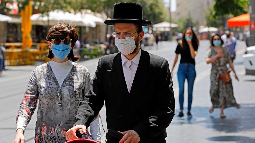  A Haredi couple wears masks as they walk in Jerusalem 