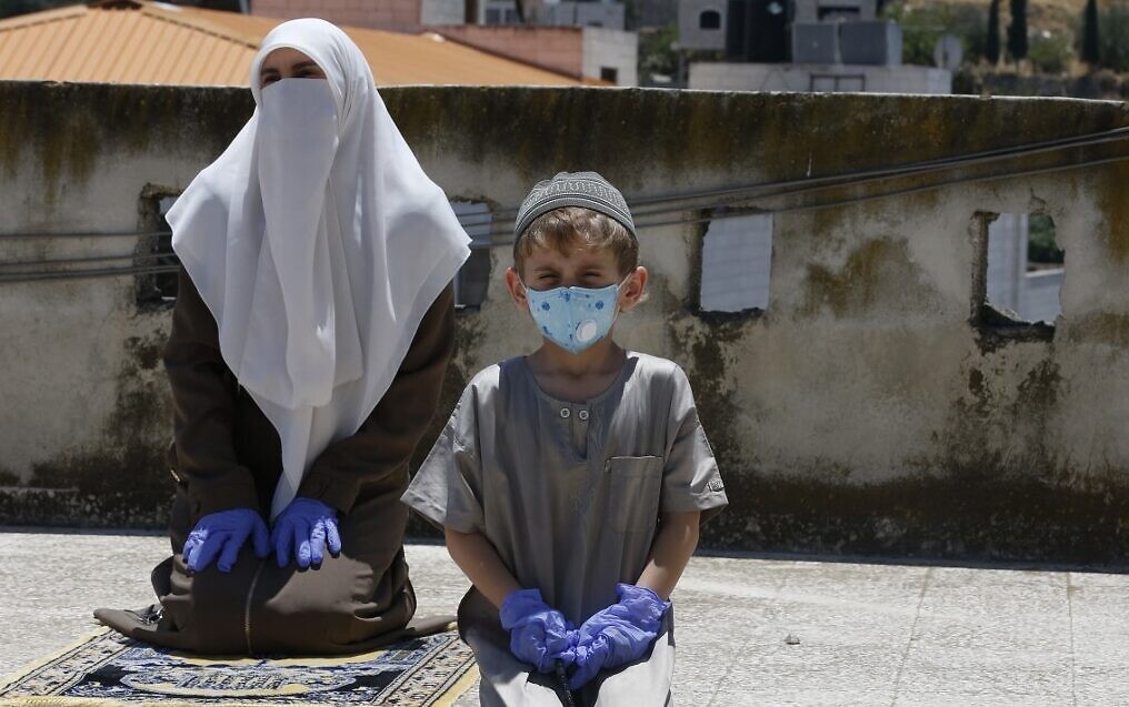 Palestinians with masks to protect against coronavirus in hard hit Hebron on the West Bank 