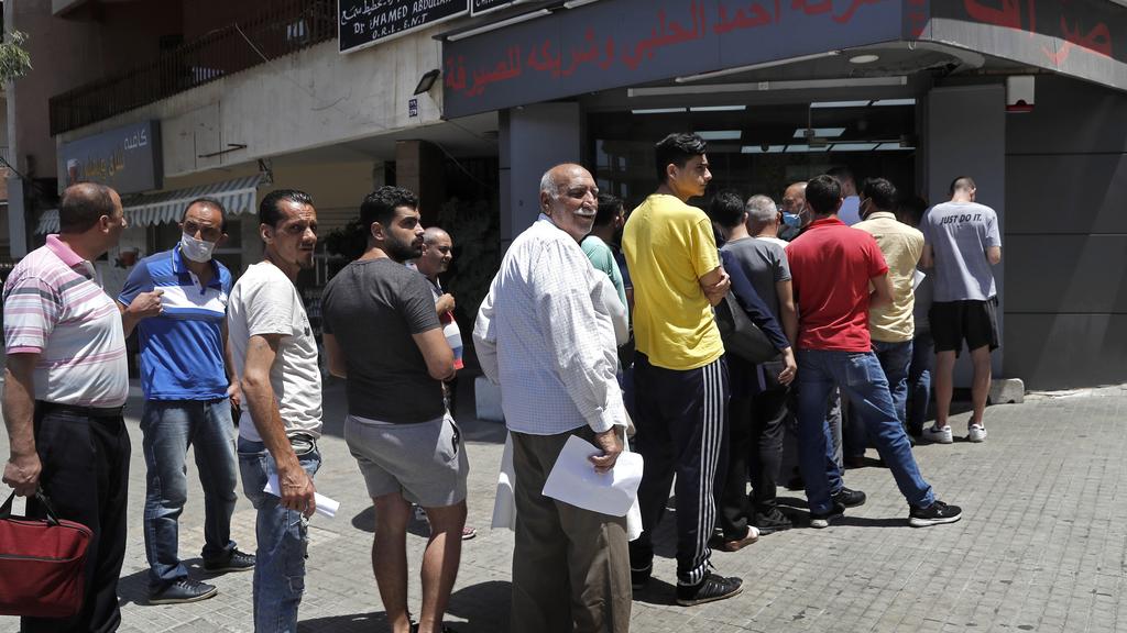People line up outside an exchange shop to buy U.S. dollars, in Beirut, Lebanon