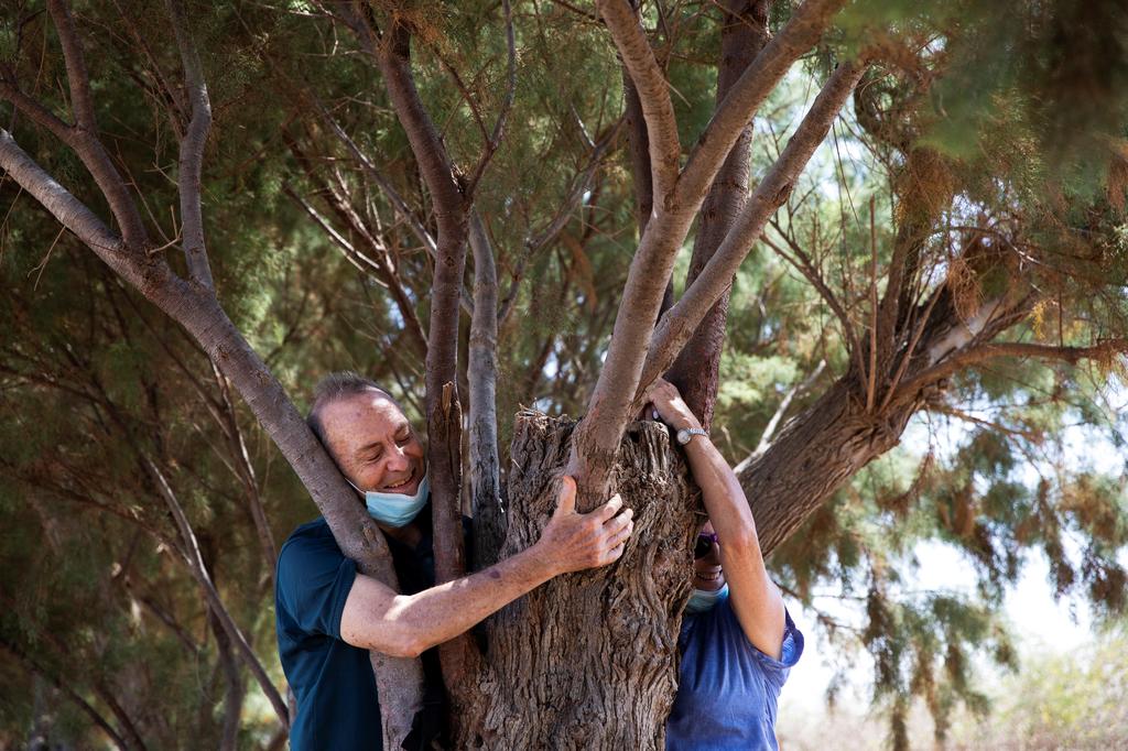 A couple take part in a campaign by Israel's Nature and Parks Authority calling on Israelis to join sightseeing tours and find comfort in tree hugging amid a spike in the coronavirus disease (COVID-19), in Apollonia National Park, near Herzliya, Israel 