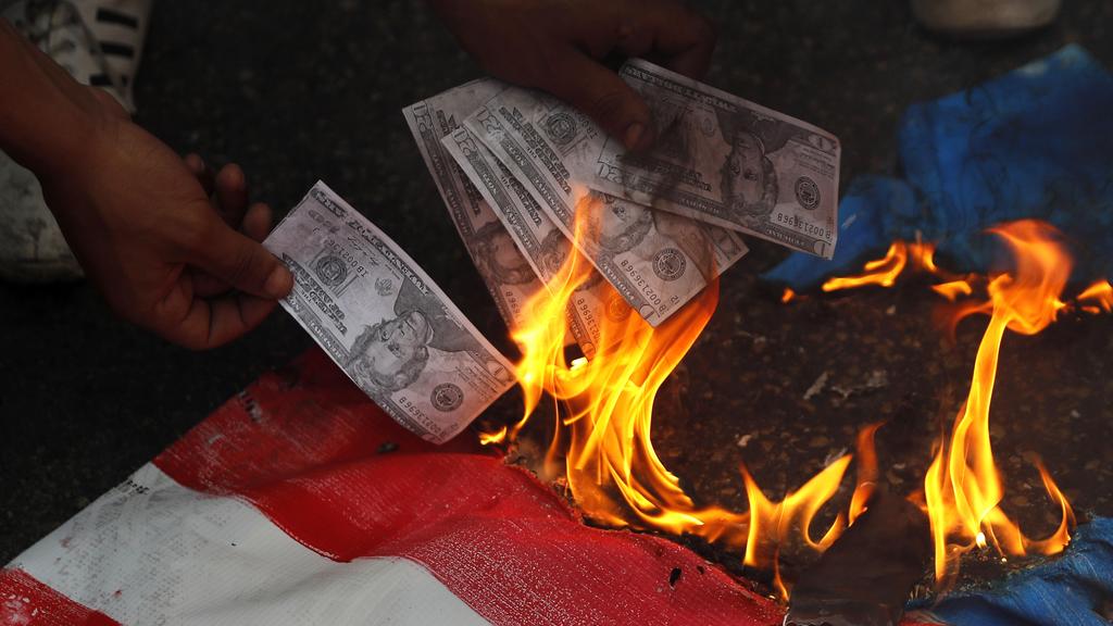 Lebanese protester burning U.S. currency, during a protest against U.S. interference in Lebanon's affairs,
