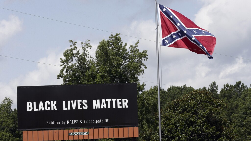 A Black Lives Matter billboard is seen next to a Confederate flag in Pittsboro, N.C