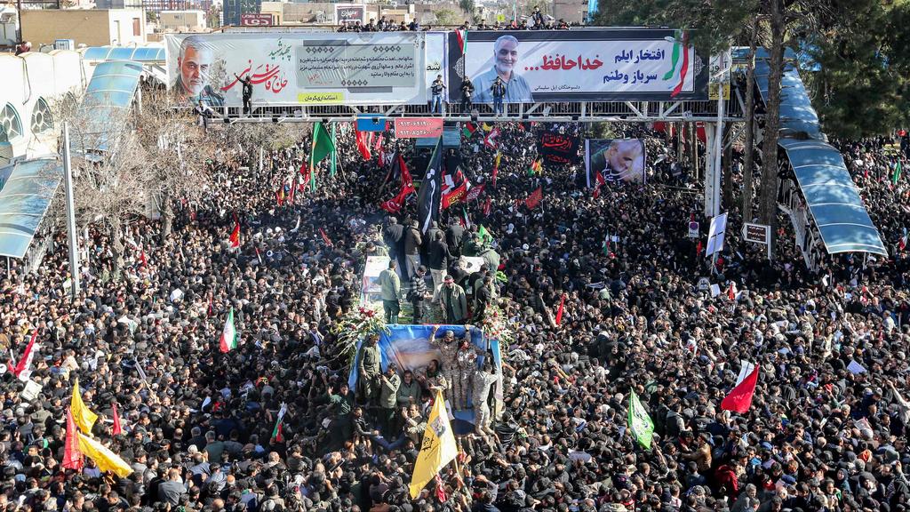  Iranian mourners gather around a vehicle carrying the coffin of slain top general Qasem Soleimani