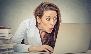 אישה בהלם מול מחשב