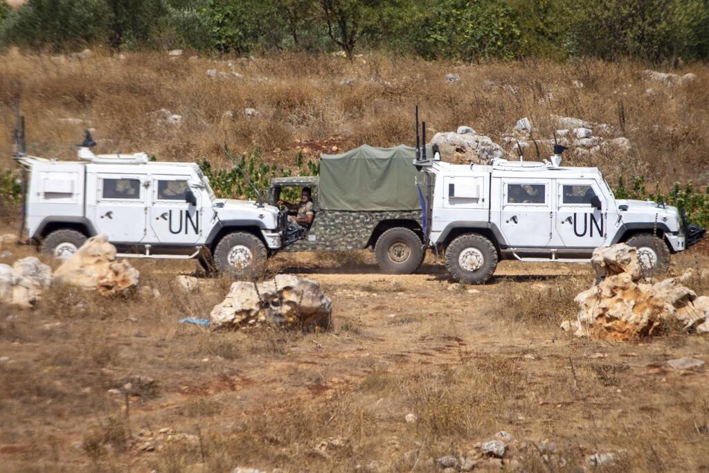 Lebanese soldiers on patrol drive by UN vehicles on the border with Israel, July 28, 2020 