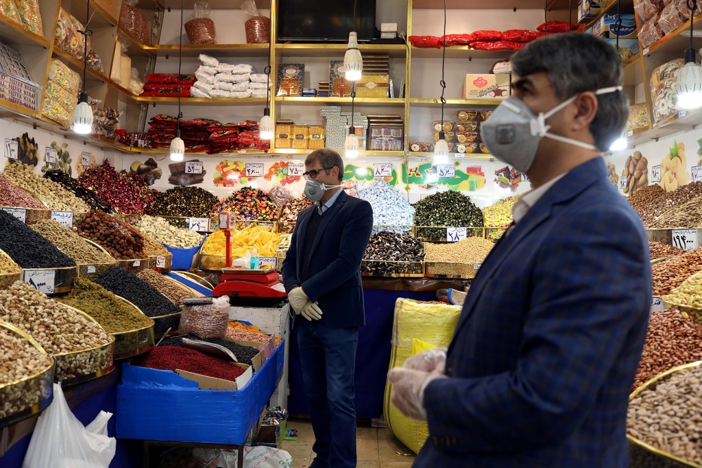 Men wear protective face masks and gloves in a food shop in Tehran following the outbreak of coronavirus 