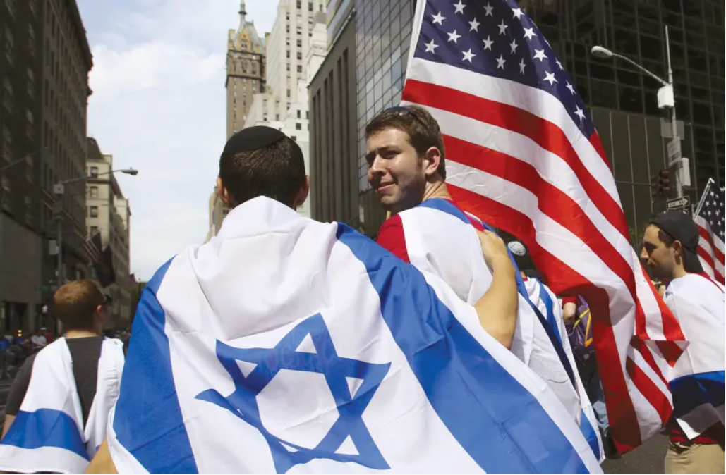 People hold U.S. and Israel flags as they chant during a Pro-Israel rally outside the Israeli consulate in New York 