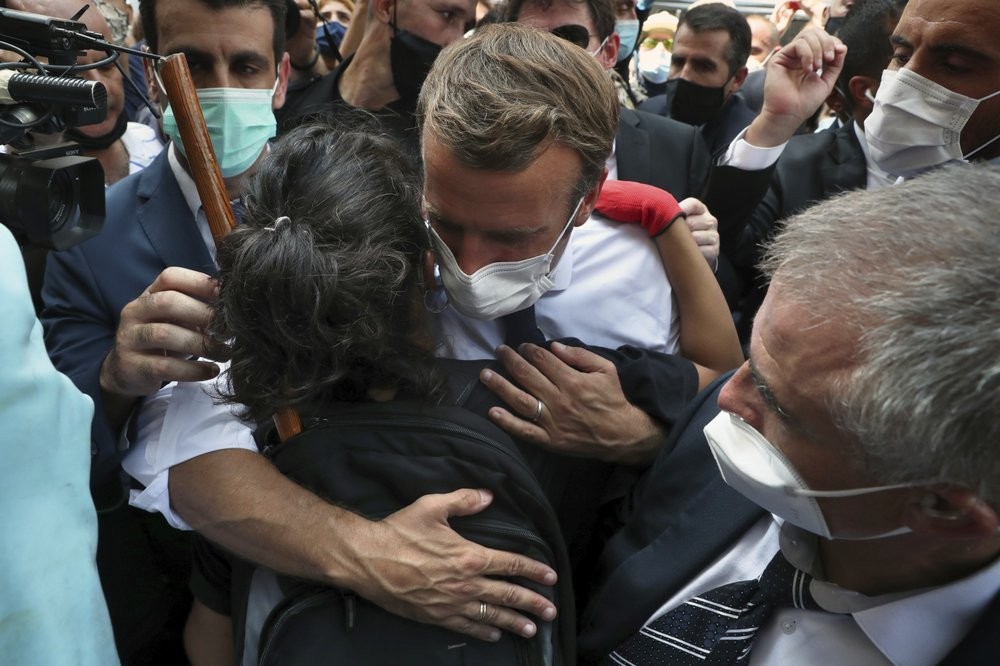 French President Emmanuel Macron, hugs a woman as he visits the Gemayzeh neighborhood, which suffered extensive damage from an explosion on Tuesday that hit the seaport of Beirut, Lebanon 