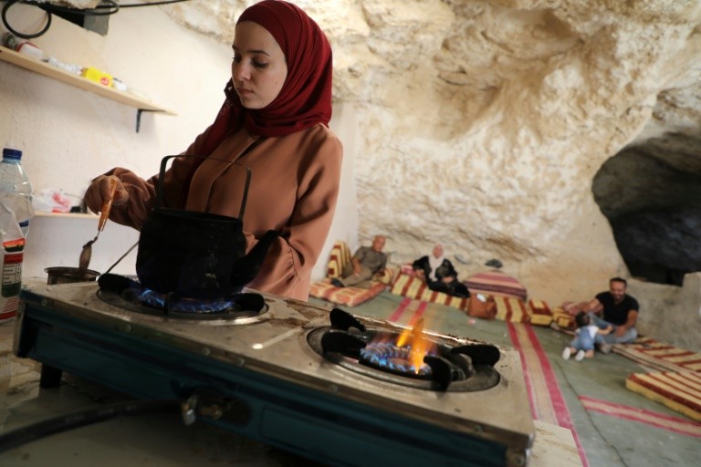 The wife of Ahmed Amarneh prepares coffee at his home 