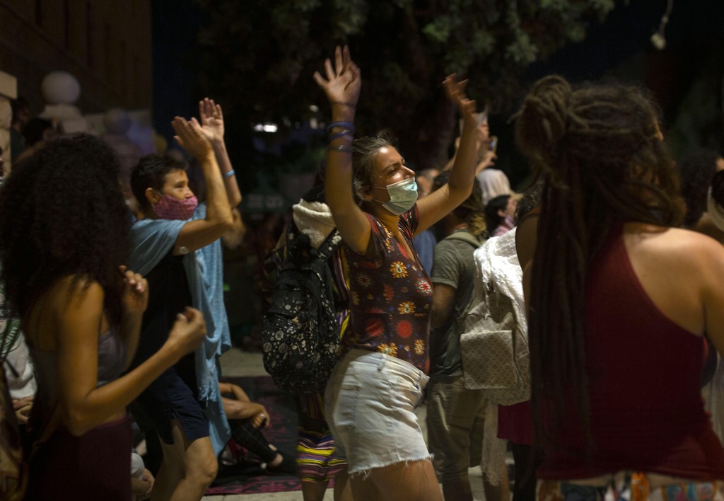 A woman dances during a protest against Israel's Prime Minister Benjamin Netanyahu outside his residence in Jerusalem 