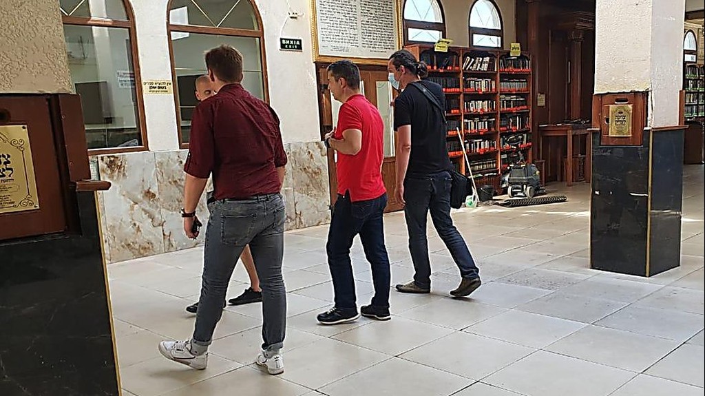  Цебрий (в центре) отказался надеть кипу при входе в синагогу