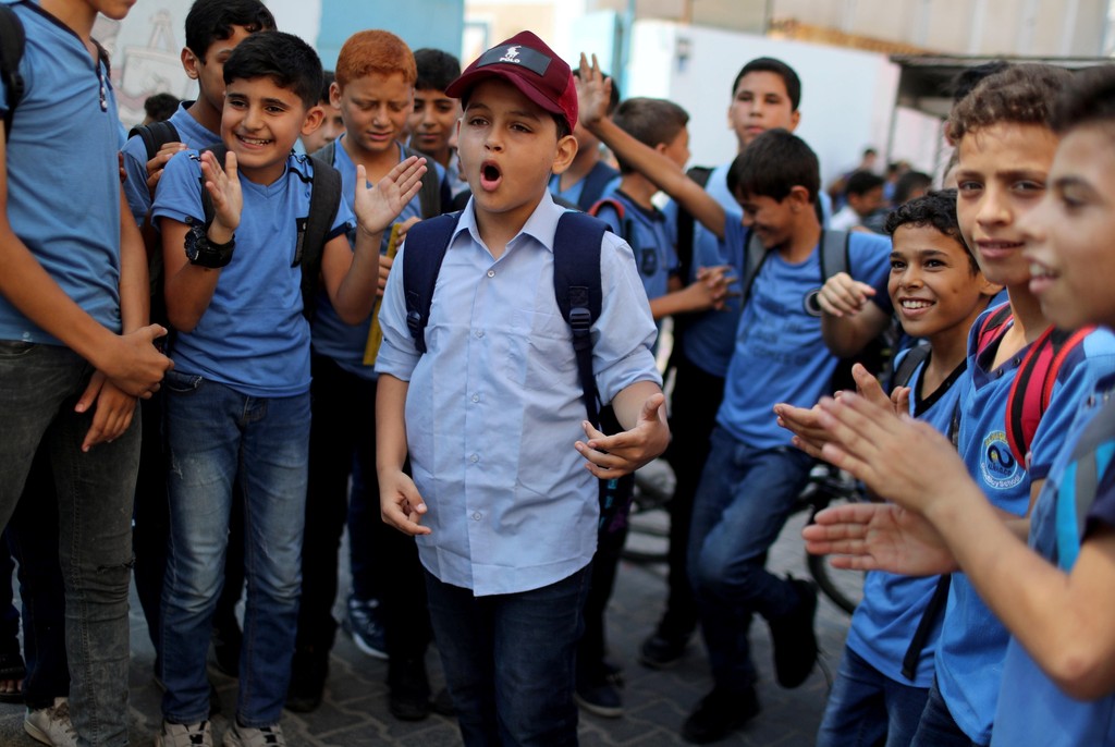 Abdel-Rahman Al-Shantti, an 11-year-old Gaza rapper, is surrounded by students as he performs in his school in Gaza City 