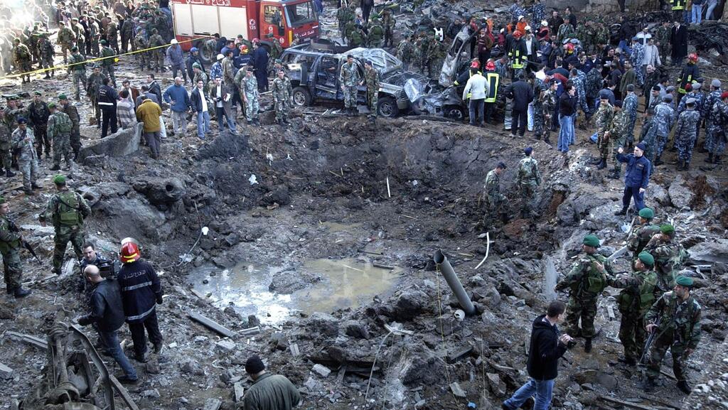  Rescue workers and soldiers stand around a massive crater after a bomb attack that tore through the motorcade of former Prime Minister Rafik Hariri