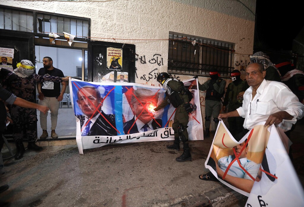 Palestinians burn banners depicting Abu Dhabi Crown Prince Mohammed bin Zayed al-Nahyan (R), Israeli Prime Minister Benjamin Netanyahu (L) and US President Donald J. Trump (C), during a protest against the peace agreement