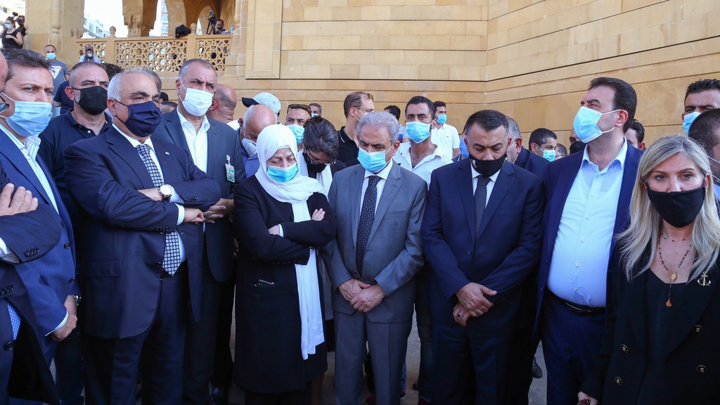 Rafik Hariri's sister Bahia and supporters stand at his Beirut gravesite on the day the tribunal on his assassination announces its verdict, Aug, 18, 2020 