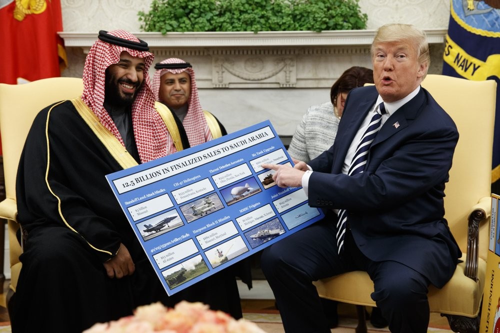 President Donald Trump shows a chart highlighting arms sales to Saudi Arabia during a meeting with Saudi Crown Prince Mohammed bin Salman in the Oval Office of the White House in Washington 