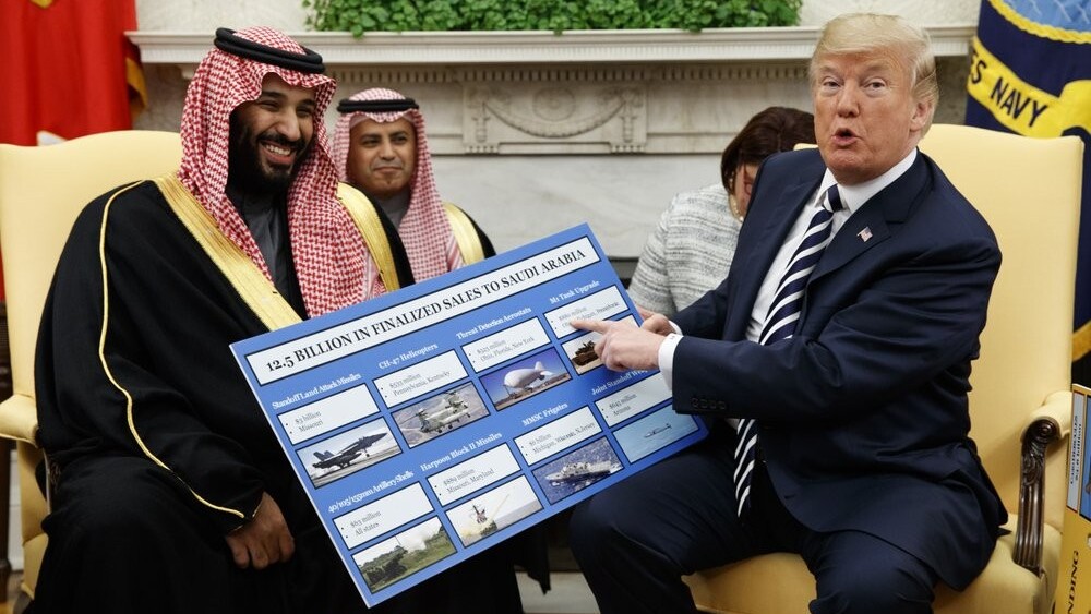President Donald Trump shows a chart highlighting arms sales to Saudi Arabia during a meeting with Saudi Crown Prince Mohammed bin Salman in the Oval Office of the White House in Washington 