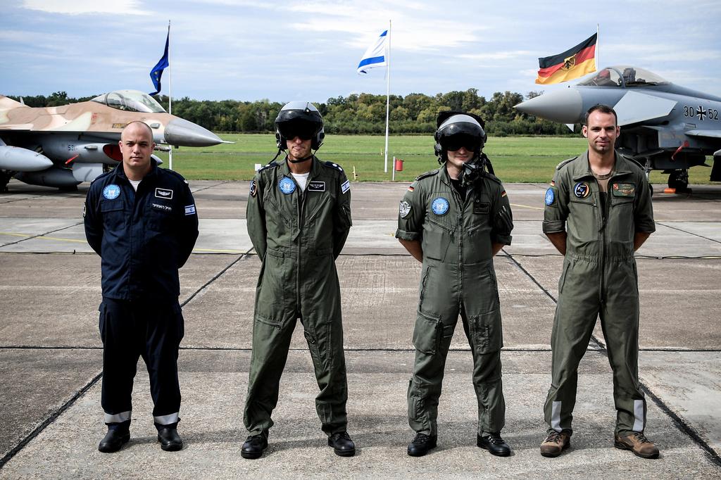 Pilots and technicians from Israel (L) and from Germany (R) pose in front of an Israeli F-16C/D 'Barak' (L) and a Bundeswehr Eurofighter (R)