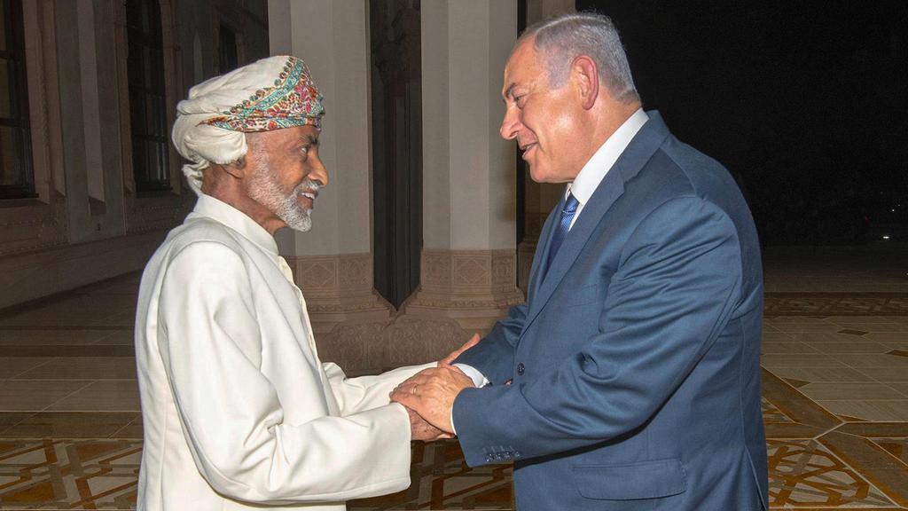 , Oman's Sultan Qaboos, left, greets Israeli Prime Minister Benjamin Netanyahu in Muscat, Oman