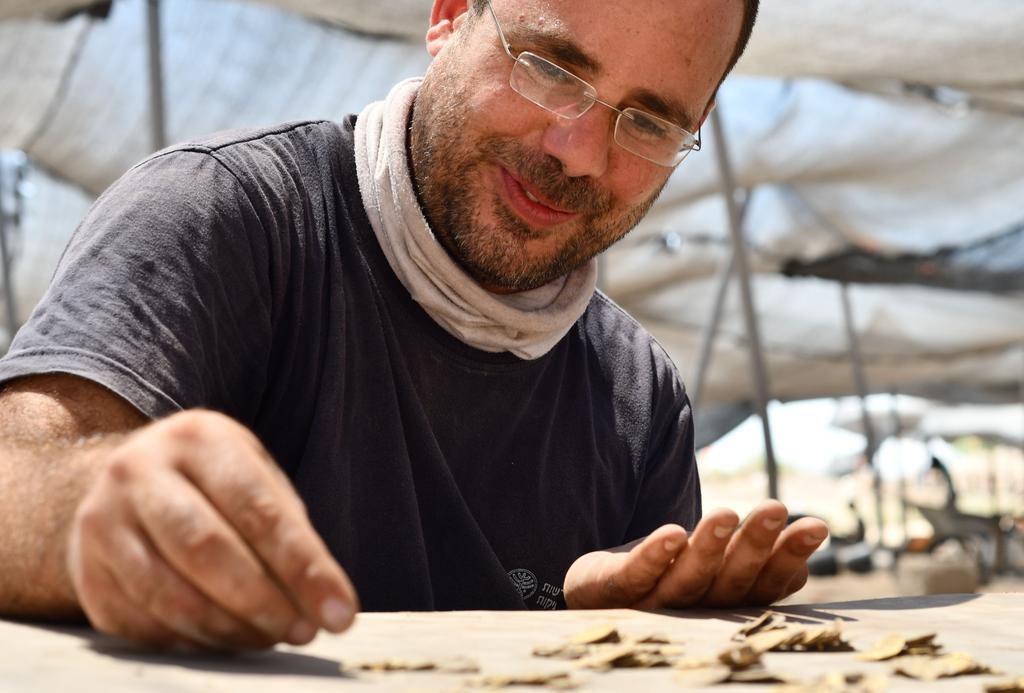 שחר קריספין, מומחה מטבעות ברשות העתיקות, סופר את מטבעות הזהב שנחשפו