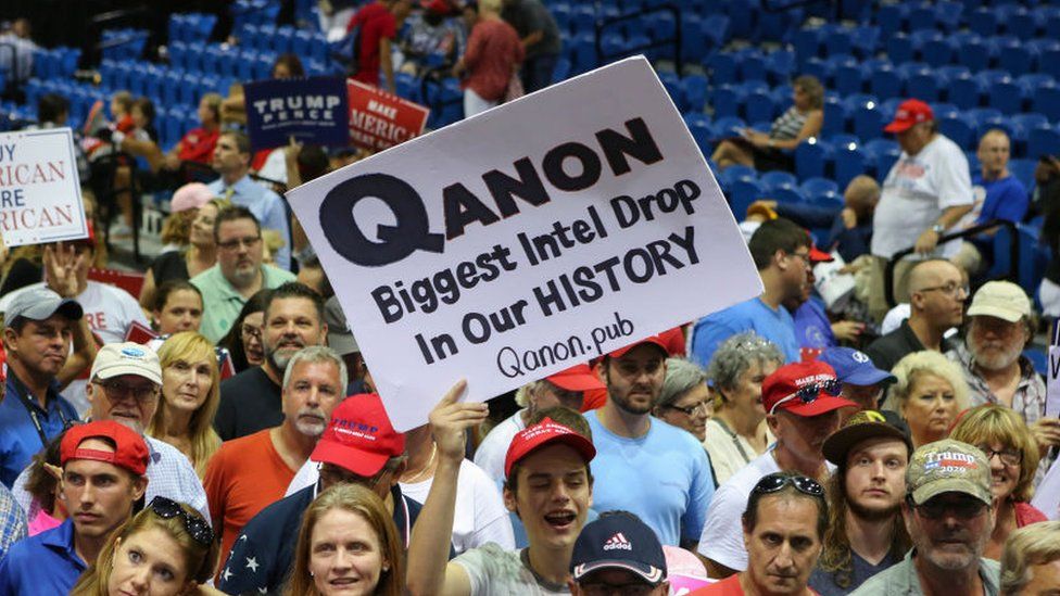Supporters displaying QAnon posters appeared at Trump rallies last summer 