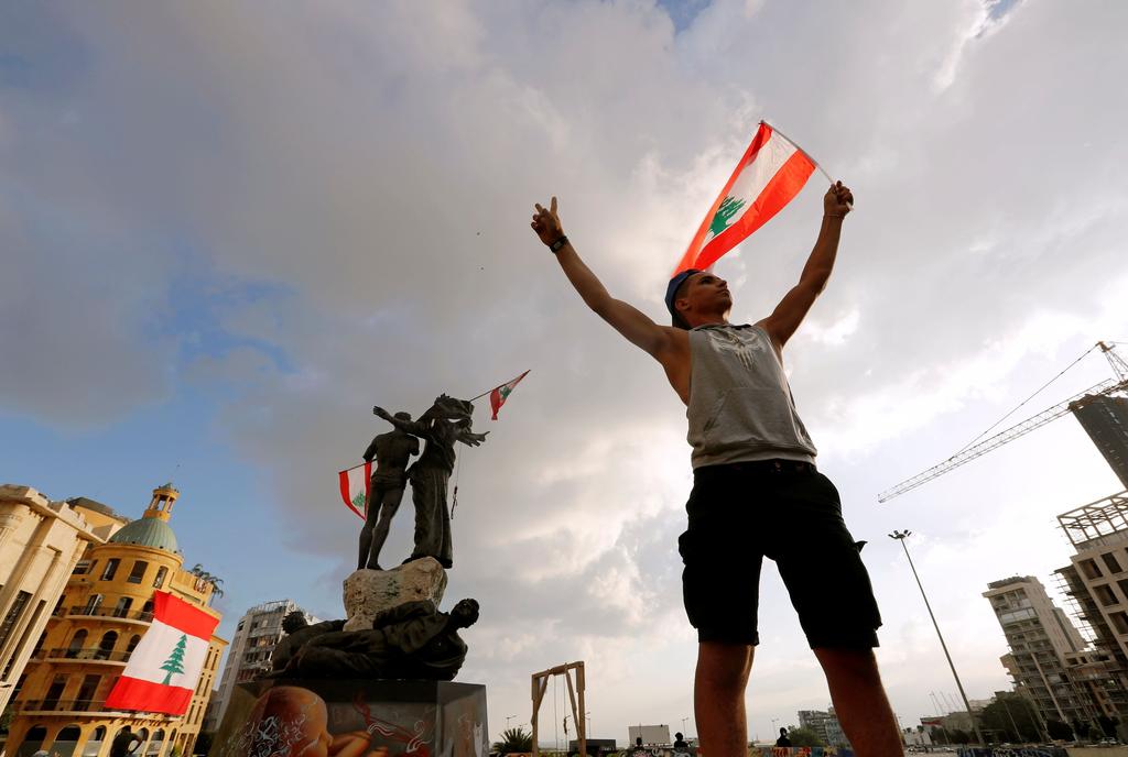 A demonstrator holds the Lebanese flag in Martyrs' Square 