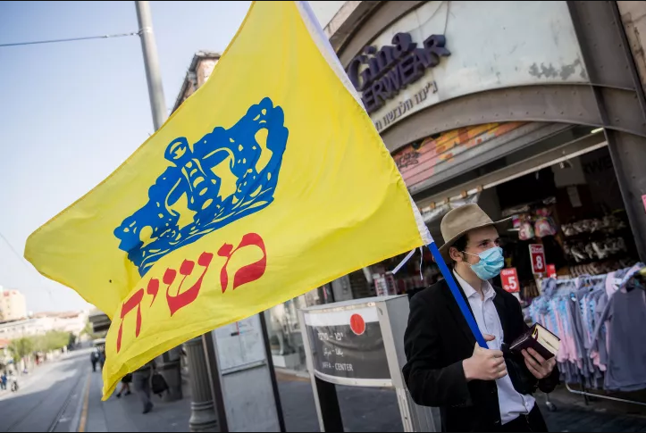 Illustrative: A man holds a Chabad flag on Jaffa street in downtown Jerusalem on April 20, 2020