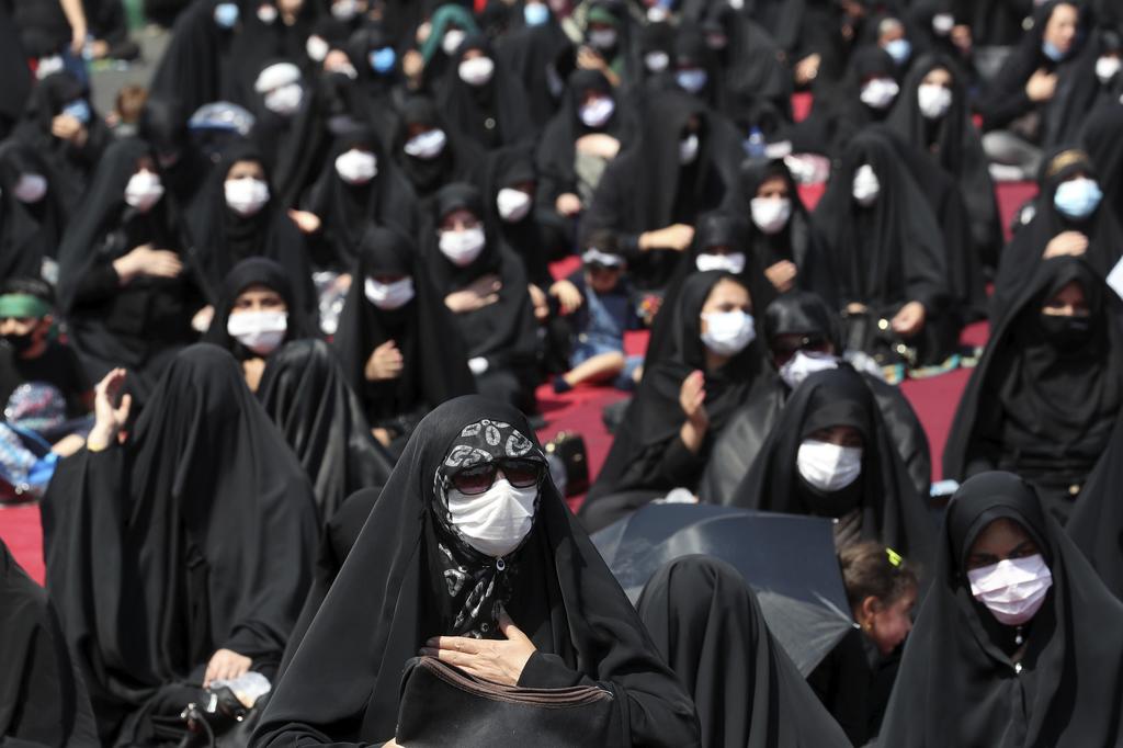 People wearing protective face masks to help prevent spread of the coronavirus mourn during an annual ceremony commemorating Ashoura, the anniversary of the 7th century death of Imam Hussein, a grandson of Prophet Muhammad, and one of Shiite Islam's most beloved saints, who was killed in a battle in Karbala in present-day Iraq, at the Saleh shrine in northern Tehran, Iran 