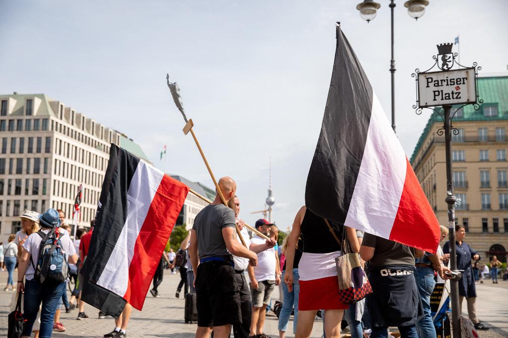 Persons with Reich flags are standing on Pariser Platz the day after a protest against the Corona measures 
