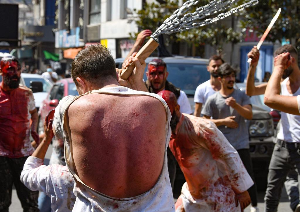 A Lebanese Shiite Muslim man flagellates himself after cutting his scalp to bleed, in a mourning ritual on the tenth day of the month of Muharram which marks the peak of Ashura, in the southern Lebanese city of Nabatiyeh 