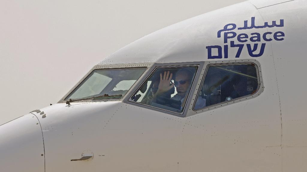 The captain of the El Al airliner which will carry US and Israeli delegations to the United Arab Emirates waves to spectators as the plane prepares to take off on the first-ever commercial flight from Israel to the UAE