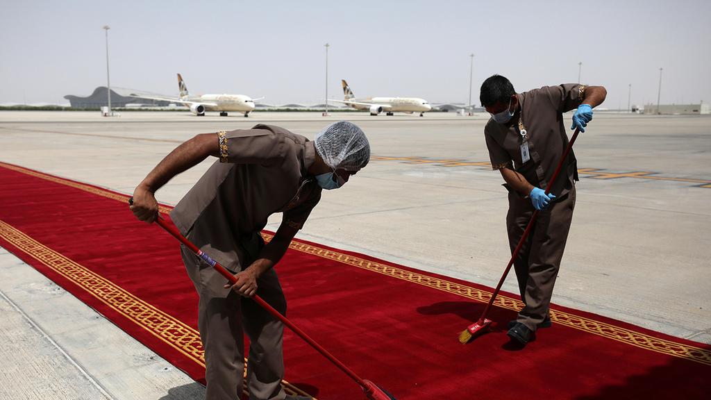 Emtrati workers prepare a red carpet for the U.S. and Israel delegations arriving in Abu Dhabi (Photo: Reuters) מנקים את השטיח האדום