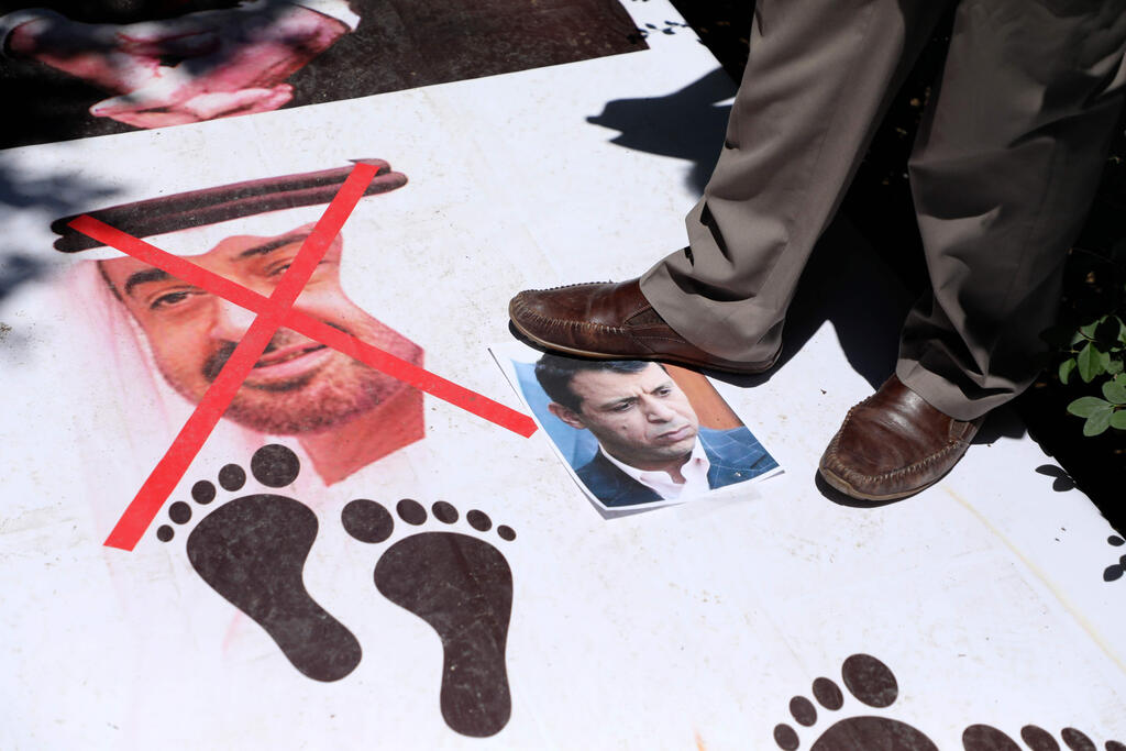Palestinian protestors step on portraits of Abu Dhabi Crown Prince Sheikh Mohammed bin Zayed Al-Nahyan, and Palestinian politician Mohammed Dahlan, during a national conference against the Emirati-Israeli agreement