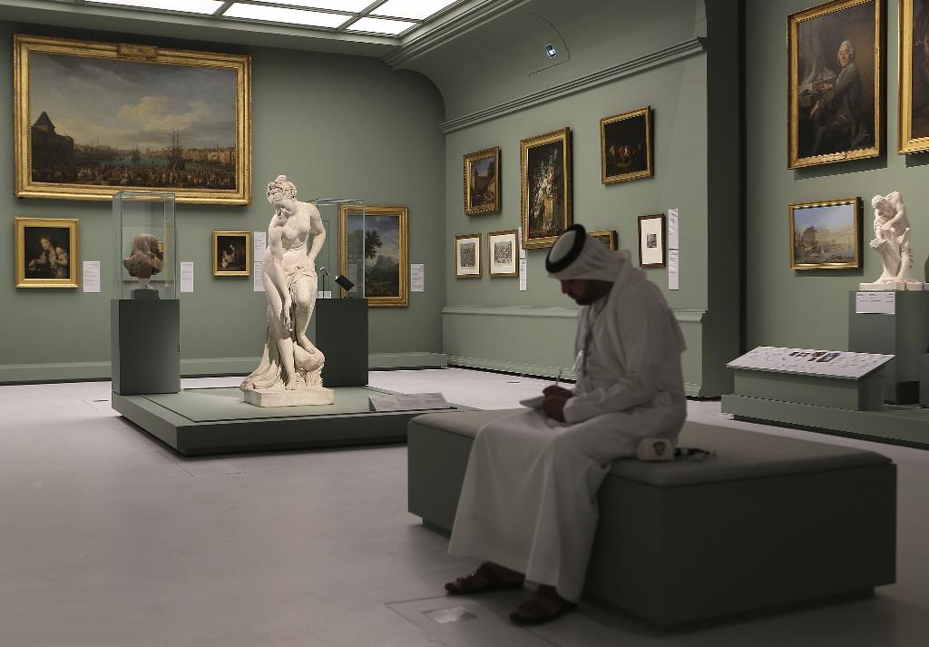 An Emirati man next to the Bather, also called Venus statue by Christophe-Gabriel Allegrain, 1710-1795, at the Louvre Museum in Abu Dhabi, United Arab Emirates 