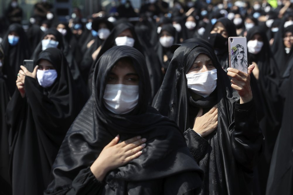 people wearing protective face masks to help prevent spread of the coronavirus mourn during an annual ceremony commemorating Ashoura in Tehran, Iran 