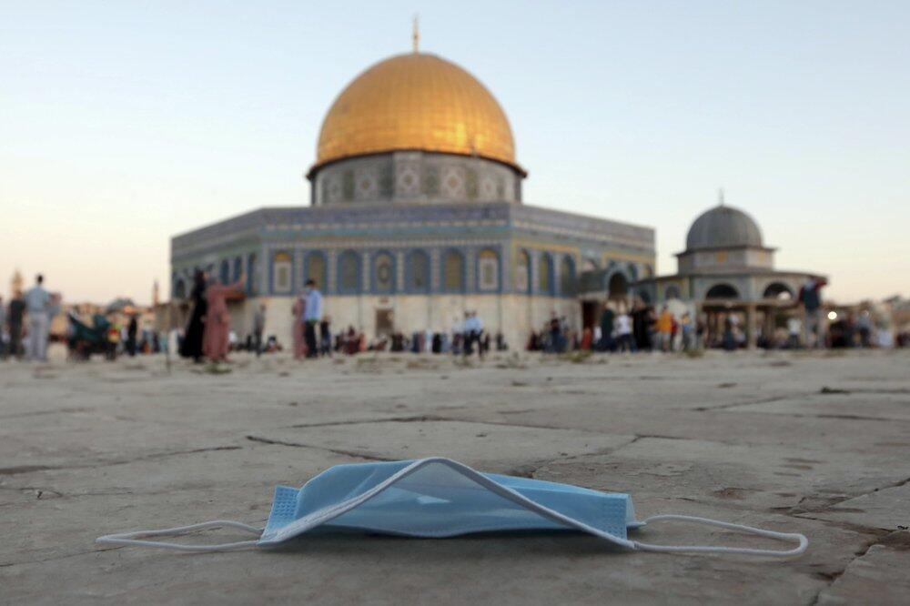a protective face mask is left on the ground during the Eid al-Adha prayers, next to the Dome of the Rock Mosque in the Al Aqsa Mosque compound in Jerusalem's Old City 