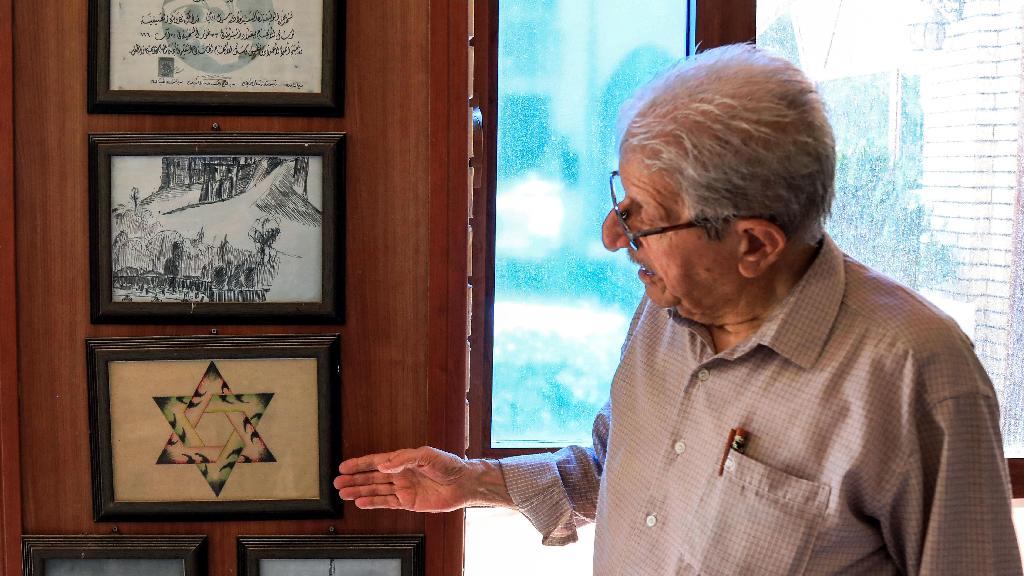 Omar Farhadi, an elderly Iraqi Kurd points to a frame showing a stylized hexagram, or a Star of David, hanging in a room dedicated to famous Jewish Kurdish art teacher and painter Daniel Kassab