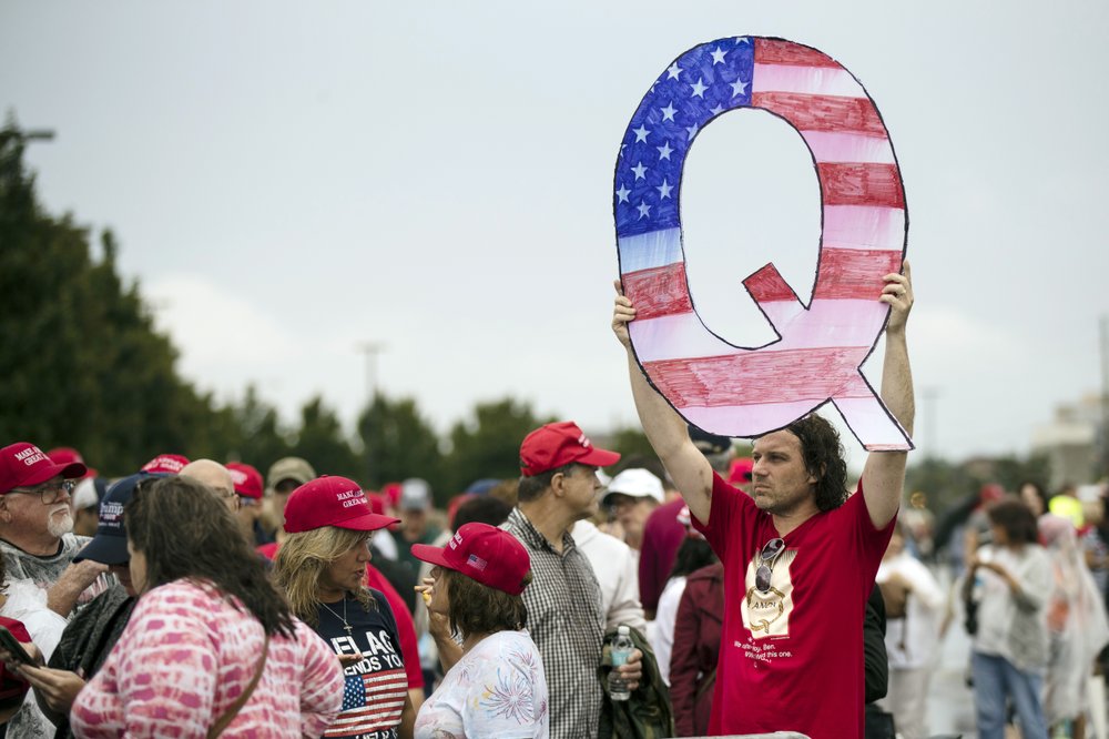 a protesters holds a Q sign waits in line with others to enter a campaign rally with President Donald Trump in Wilkes-Barre, Pa. 