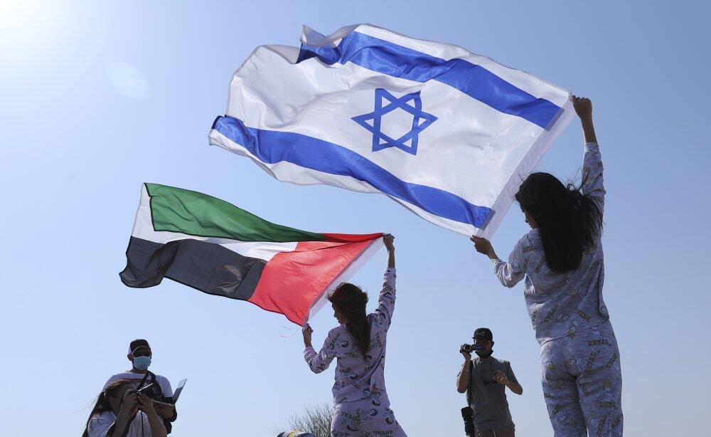 Israeli model May Tager, right, holds Israel's blue-and-white flag bearing the Star of David while next to her Anastasia Bandarenka, a Dubai-based model originally from Russia, waves the Emirati flag, during a photo shoot in Dubai, United Arab Emirates 