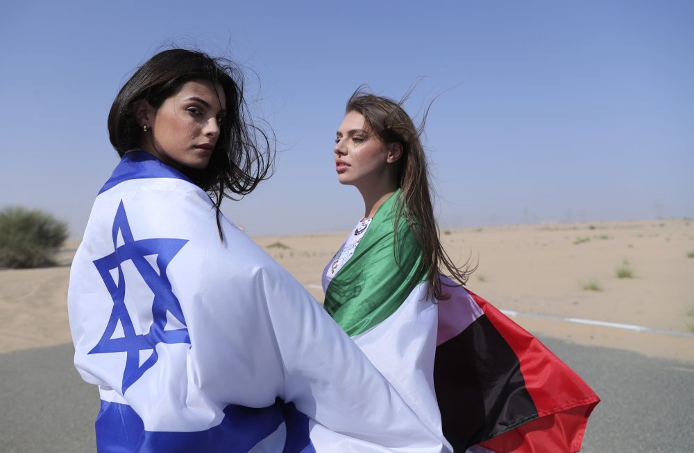 Israeli model May Tager, left, covers herself with an Israeli flag next to Anastasia Bandarenka, a Dubai-based model who covers herself in a UAE flag on the set of a photo shoot in Dubai, United Arab Emirates 