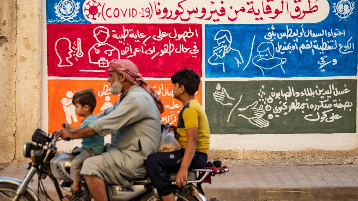 A mural in the Kurdish-majority city of Qamishli in northeastern Syria urges people to protect themselves from the virus as part of a campaign by the UN childre's fund UNICEF and the World Health Organization 