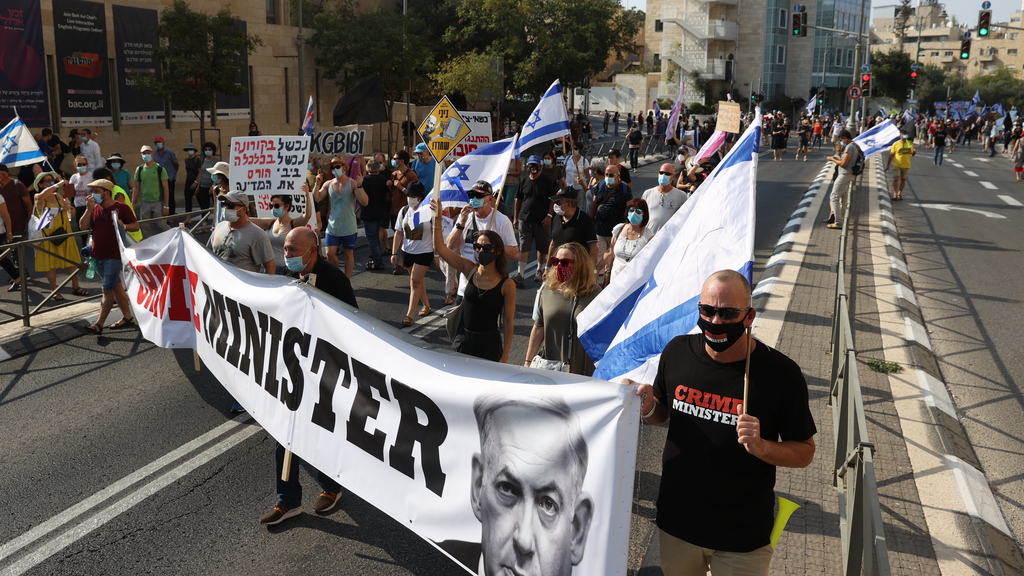  Anti-Netanyahu protesters carrying a banner reading 'crime minister' marching in Jerusalem in September 